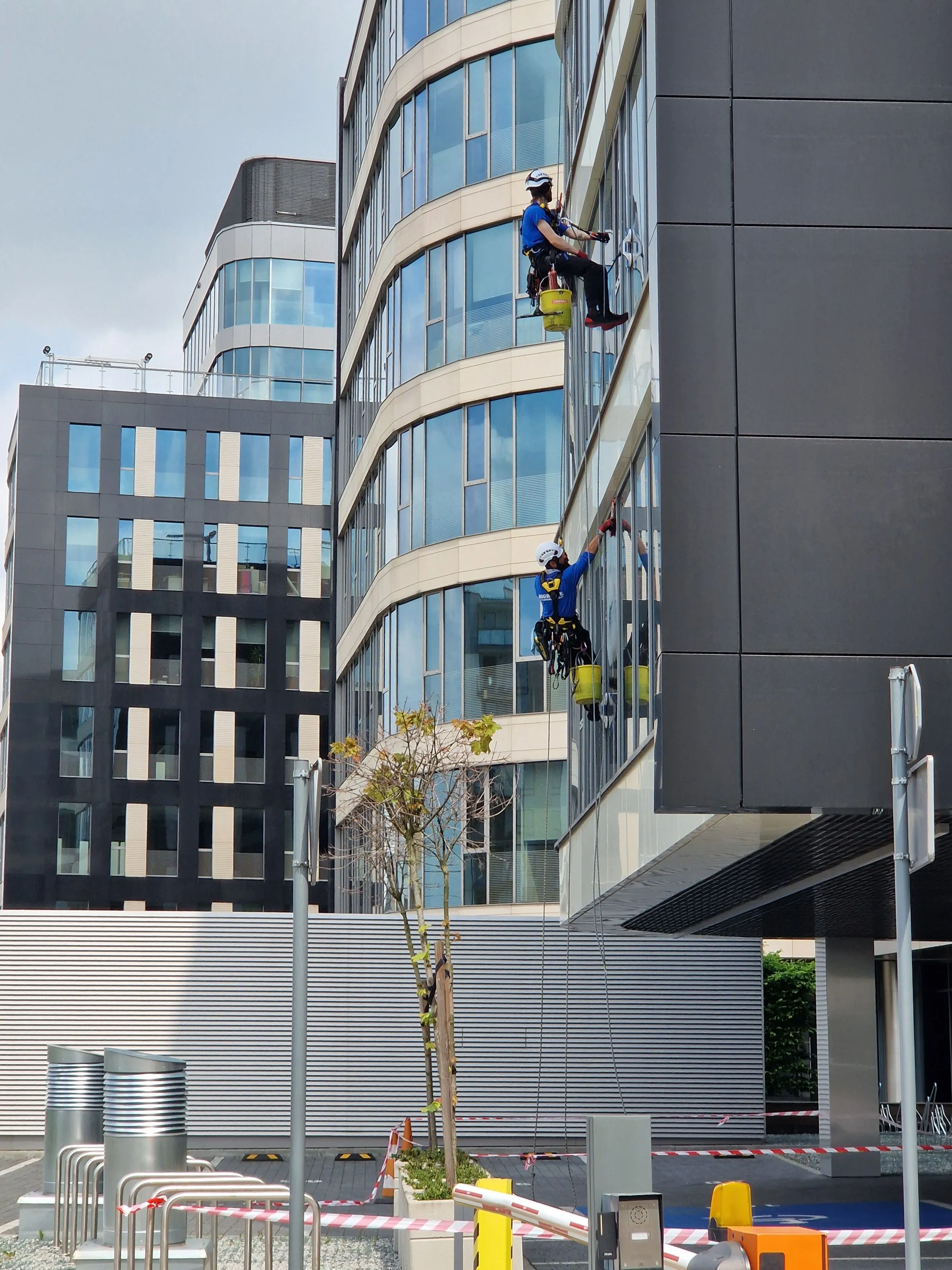 Fensterreinigung an einer Glasfassade im Abseilverfahren, durchgeführt von Plan B Facility